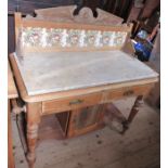 An Edwardian marble topped pine wash stand, with tiles to the back, fitted with two frieze drawers