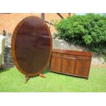 A reproduction tilt top oval dinning table with cross band decoration length 66ins, width 46ins,