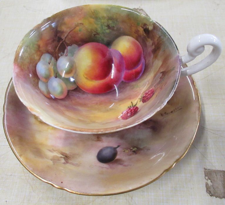 An unmarked Royal Worcester cup, decorated to the interior and exterior with fruit to a mossy