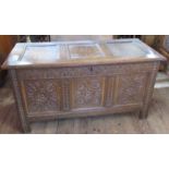 An Antique oak coffer, with carved decoration to the front, 52ins x 23.5ins, height 27.5ins