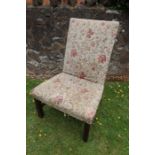 A 19th century upholstered easy chair raised on square legs united by stretchers