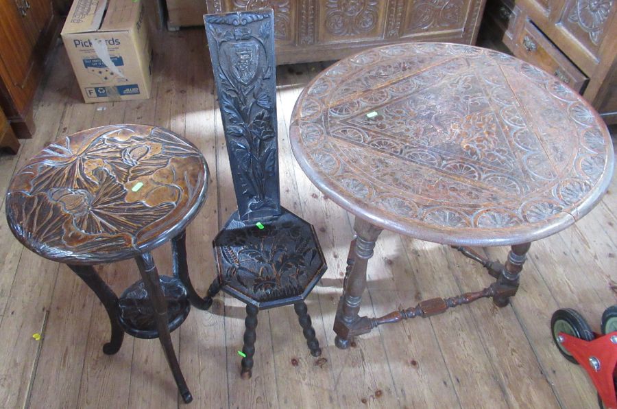 A circular carved drop flap table, diameter 28ins, together with a carved milking chair and a carved