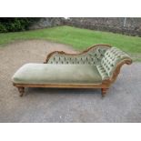 A Victorian mahogany and upholstered chaise longue with carved decoration and a buttoned back,