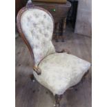 A Victorian walnut framed nursing chair, with carved decoration