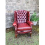A deep button back leather wing arm chair (TRADE ONLY)