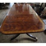 A twin pedestal mahogany table with two leaves   125.5ins x 48.5ins height 29.5ins closed length