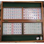 A cased mah jong set, with plastic tiles, together with a travelling backgammon game