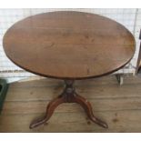 An Antique oak tripod table, raised on a turned column with three outswept supports, diameter 29.