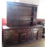 A large Antique dresser, with close boarded rack bask, having a pair of cupboards, the base fitted