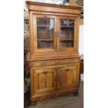 A 19th century French walnut cabinet, the upper section having a pair of glazed doors revealing