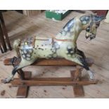 An Antique painted wooden rocking horse, with remains of leather tack, on a pine base, height 32ins,