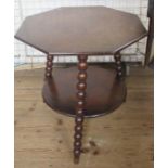 A walnut octagonal table, raised on three bobbin turned legs, with circular undershelf, diameter