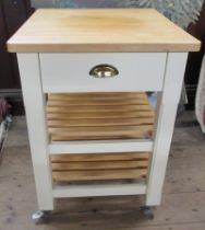 A modern pine topped and painted kitchen trolley, on wheels, fitted with a drawer over shelves, 23.