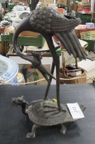 A Japanese Bronze model of a stork, standing on a mythical creature