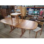 A mid century teak extending dining table, with 2 extra leaves, together with a set of four dining