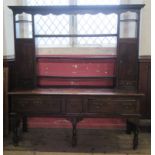 An Antique dark oak dresser, the open back with shelves and cupboards, the base fitted with drawers,