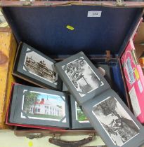 A collection of postcard albums together with a leather case