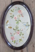 A 19th century oval tapestry on silk, of flowers, in a mahogany frame, 20ins x 13.5ins to include