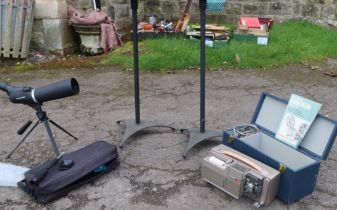 A telescope on stand, together with two stands and a projector