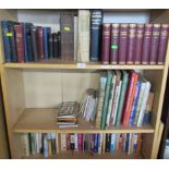 Three shelves of books and maps