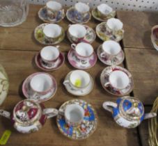 13 Continental miniature cups and saucers, together with two miniature tea pots