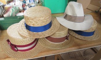 Four straw boaters, a grey top hat and another hat