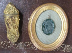 A gilt metal etui, together with a framed intaglio