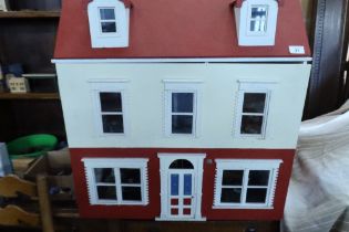 A dolls house, with a large collection of dolls house furniture, china, figures, kitchenalia etc