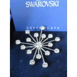 A Swarovski snowflake brooch, set with white paste, boxed, with certificate, together with a