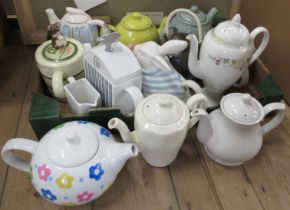 A collection of tea pots, to include novelty ones, together with a collection of pottery pebble