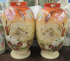 A pair of Edwardian glass vases, decorated with houses, height 13ins