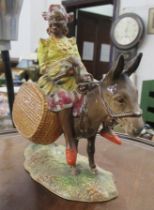 A Beswick figure, Susie Jamaica, holding fruit, sitting astride a donkey with carrying baskets, 1347