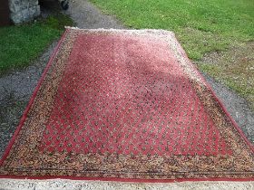 An Eastern design rug, decorated with geometric pattern to a red ground, 78ins x 119ins