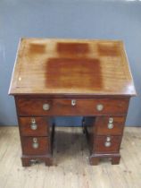 A 19th century mahogany desk, having raising top with ratcheted support, the drawer opening to