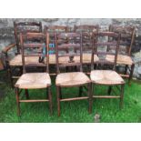 A set of four (3+1) oak ladder back chairs, with rush seats, together with another set of three