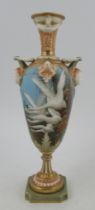 A Royal Worcester pedestal vase, decorated with swans in flight with gilt reeds to a powder blue