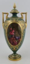 A Royal Worcester pedestal covered vase, decorated to the front with an oval panel of a still life