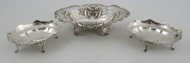 A silver pierced oval basket, af, together with a pair of silver oval dishes, with pierced border,