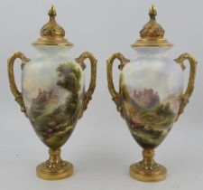 A pair of Royal Worcester covered vases, decorated all round with a castle in landscape, one with