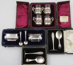 A cased set of four glass shot cups, with silver holders, together with two cased christening sets