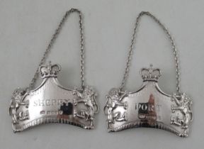 A pair of Elizabeth II silver wine labels, decorated with lions and a crown surmount, and engraved