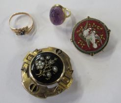 A gold coloured ring, set with a cabochon amethyst carved with a scarab beetle, together with a