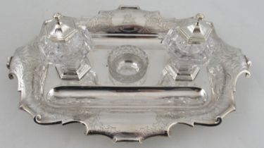 A Victorian silver desk stand, fitted with a pair of glass and silver mounted inkwells and a glass