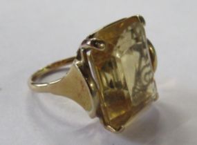 A yellow gold citrine ring, the claw set emerald cut citrine set between polished shoulders,