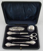 A cased silver manicure set, decorated with cherubs