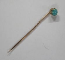 A gold stick pin, set with a turquoise