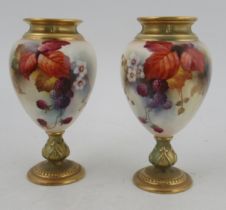 A pair of Royal Worcester pedestal vases, decorated autumnal fruits and leaves, shape number 2260,