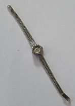 An 18K Ebel white gold lady's diamond set cocktail watch, the circular dial with baton numerals, the