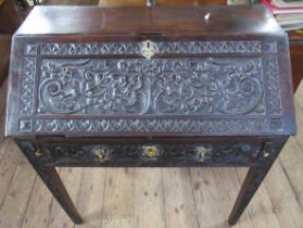 An Antique oak bureau, having carved decoration, width 33ins, height 36ins, depth 18.5ins