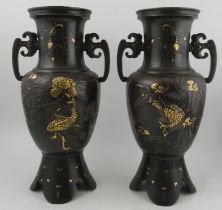 A pair of Japanese Meigi period cast vases, decorated with polished birds and foliage, raised on